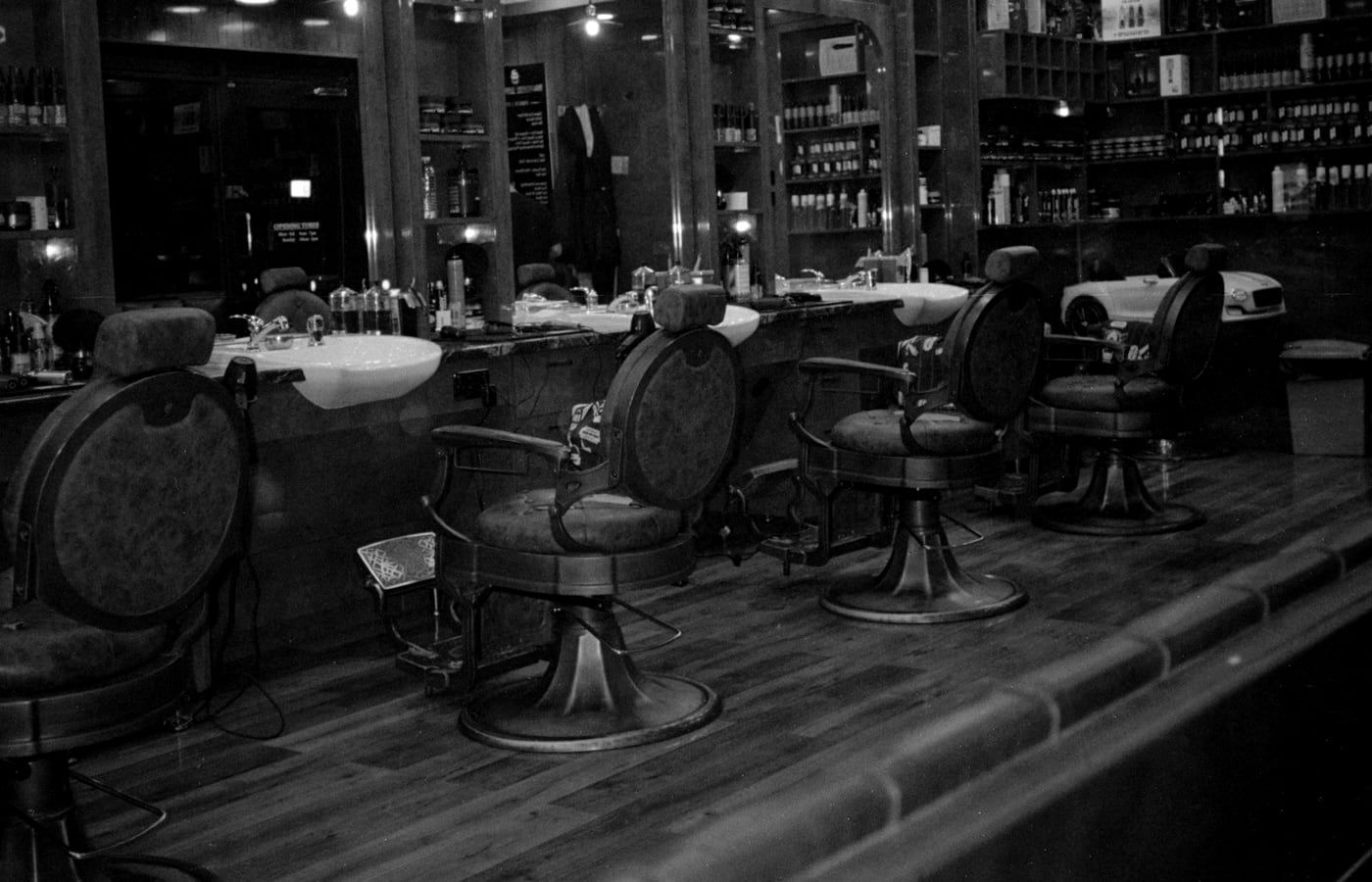 The four chairs in a row along the counter, mirrors and shelves behind them.